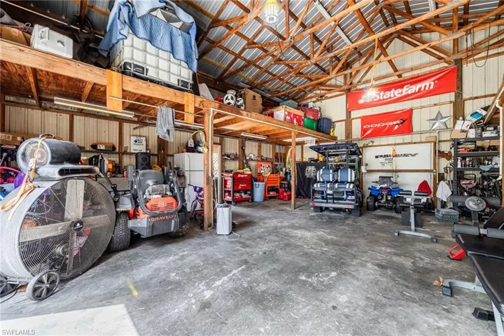 Garage with metal wall, a workshop area, and freestanding refrigerator