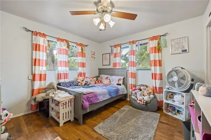 Bedroom featuring multiple windows, ceiling fan, and wood finished floors