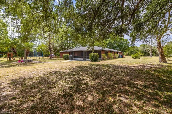 View of yard featuring a playground, a sunroom, and a trampoline