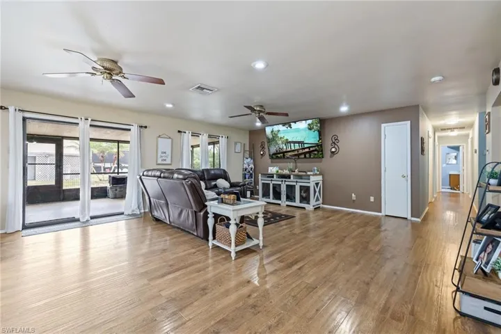 Living room featuring light wood-type flooring, recessed lighting, baseboards, visible vents, and ceiling fan