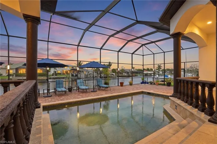 Outdoor pool with a lanai, a sunroom, a patio, and a water view
