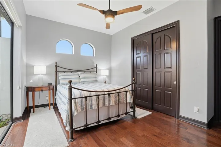 Bedroom with hardwood / wood-style flooring, a ceiling fan, and a closet
