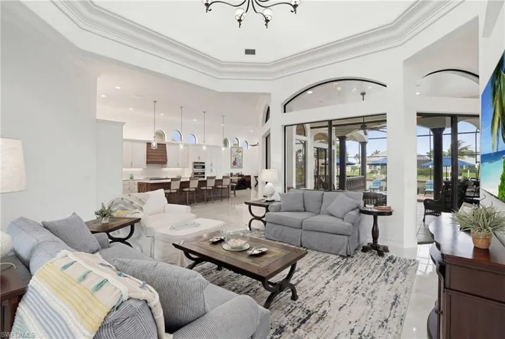 Tiled living area featuring ornamental molding and a high ceiling