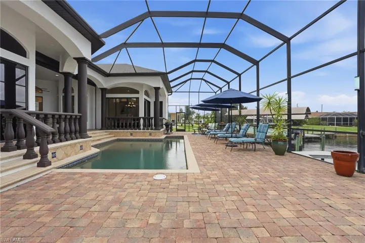 Outdoor pool featuring a patio area, glass enclosure, and a sunroom