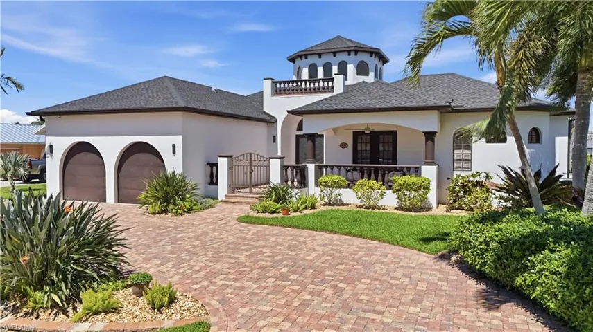 Mediterranean / spanish-style home featuring a garage, decorative driveway, stucco siding, and a gate