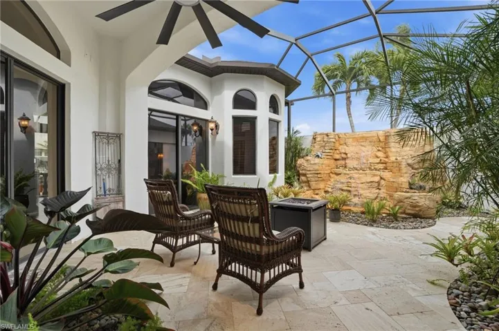 View of patio / terrace featuring a sunroom, glass enclosure, an outdoor fire pit, and a ceiling fan