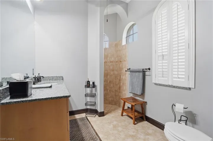 Bathroom featuring vanity, a walk in shower, and light tile patterned flooring