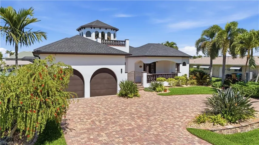 Mediterranean / spanish home with an attached garage, stucco siding, decorative driveway, and roof with shingles