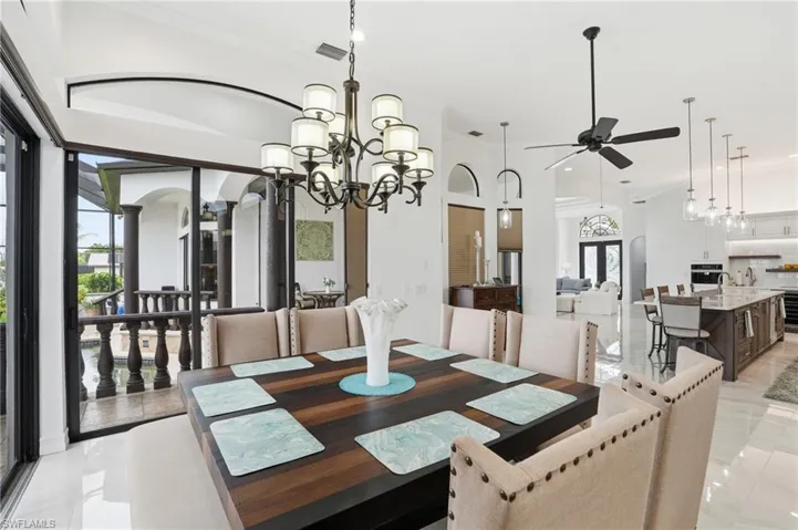 Dining area featuring ornamental molding, a chandelier, and a ceiling fan