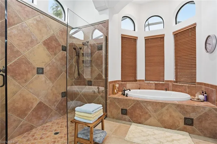 Full bath featuring a garden tub, a shower stall, and tile patterned flooring