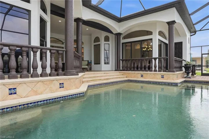 Outdoor pool featuring a sunroom, a patio, and glass enclosure