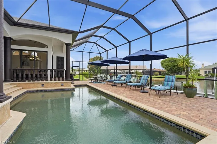 Outdoor pool featuring glass enclosure, a patio, and a sunroom