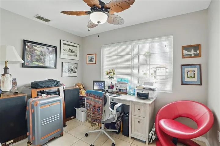 Home office with light tile patterned floors and ceiling fan