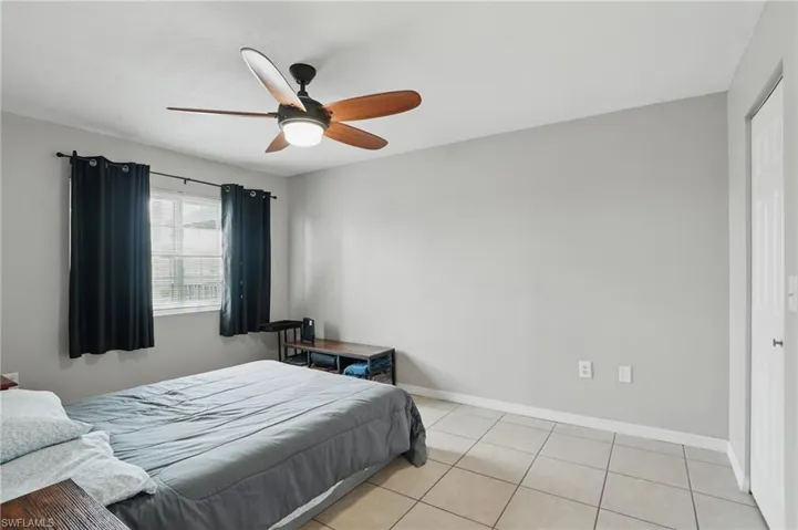 Bedroom featuring light tile patterned floors and a ceiling fan