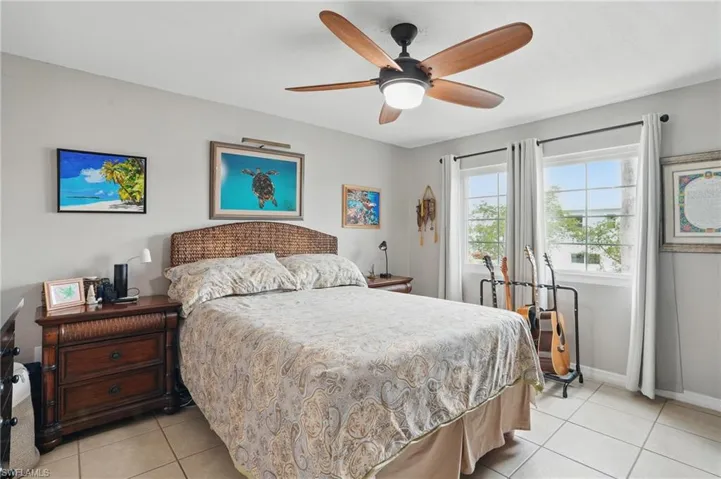 Bedroom with light tile patterned floors and a ceiling fan
