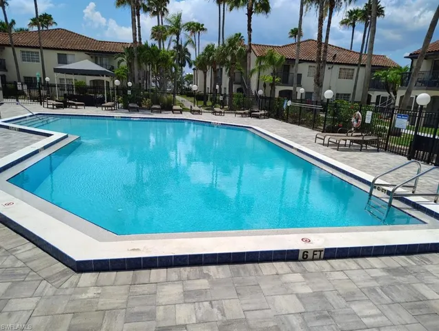 Community pool with a patio area and a residential view