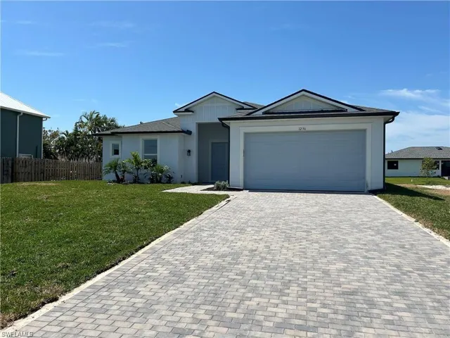 Ranch-style home with a garage and a front lawn