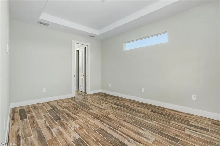 Empty room featuring a raised ceiling and hardwood / wood-style floors