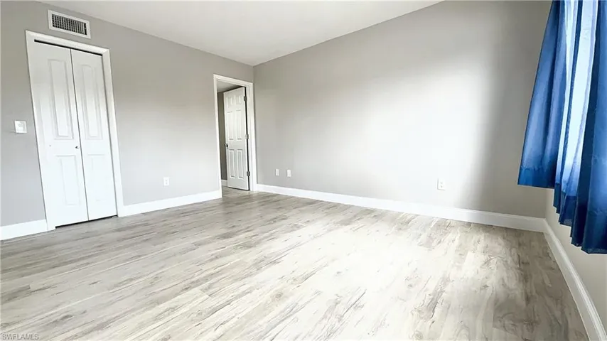 Unfurnished bedroom with a closet and hardwood / wood-style floors