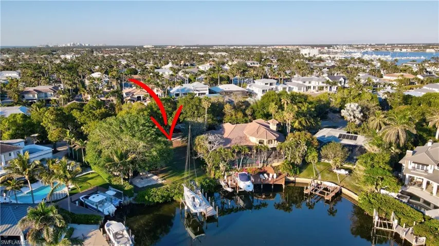 Aerial view of property's location featuring a nearby body of water and nearby suburban area