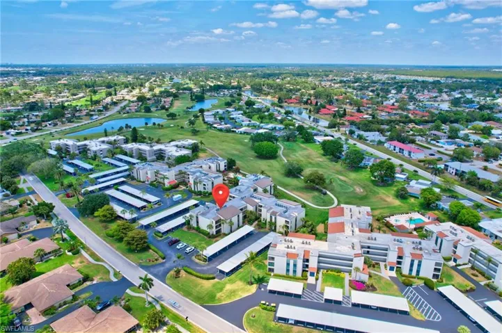 Aerial view with golf course view, a water view, and a residential view