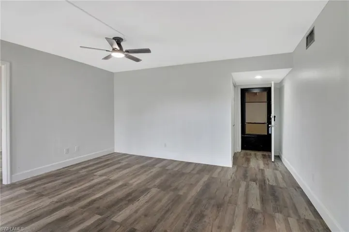 Spare room featuring ceiling fan, baseboards, wood finished floors, and visible vents