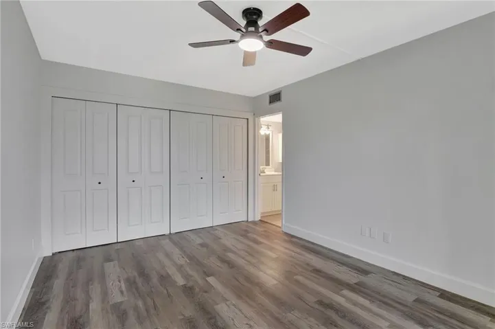 Unfurnished bedroom with baseboards, wood finished floors, and visible vents
