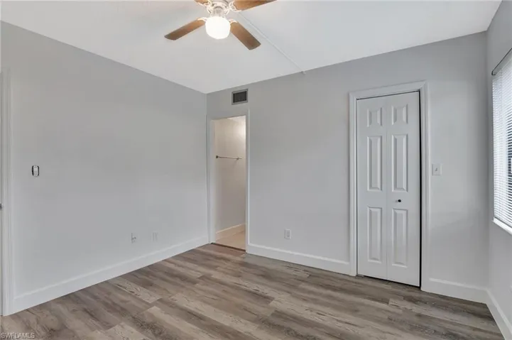 Unfurnished bedroom featuring ceiling fan, baseboards, wood finished floors, and visible vents