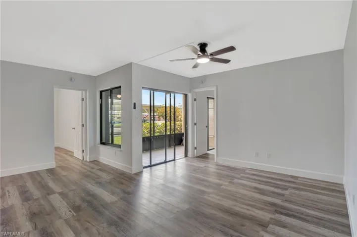 Empty room with wood finished floors, a ceiling fan, and baseboards