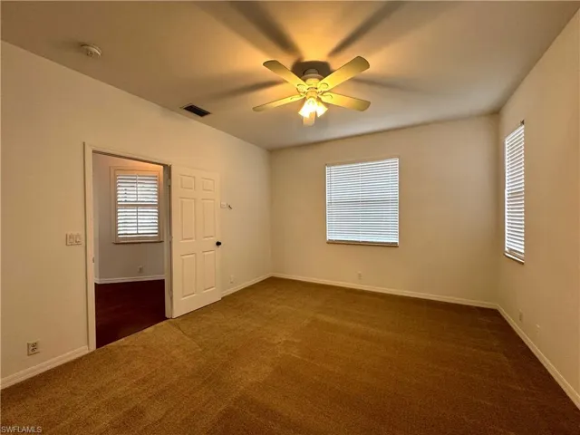 Carpeted spare room with ceiling fan