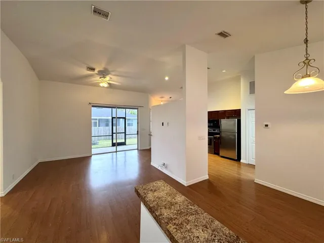 Unfurnished room with ceiling fan and dark hardwood / wood-style flooring