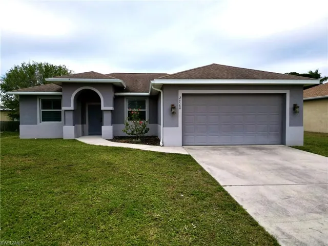 View of front of home featuring a front lawn and a garage