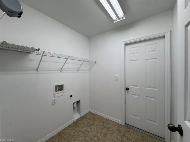 Laundry room featuring light tile patterned floors, hookup for a washing machine, and electric dryer hookup