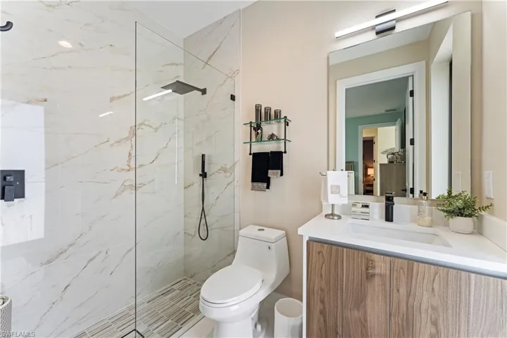 Full bathroom featuring vanity and a marble finish shower