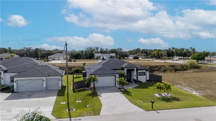 Ranch-style house featuring decorative driveway, a residential view, and a garage