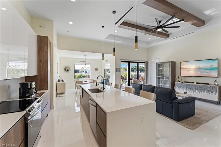 Kitchen featuring modern cabinets, appliances with stainless steel finishes, white cabinetry, recessed lighting, and light stone counters