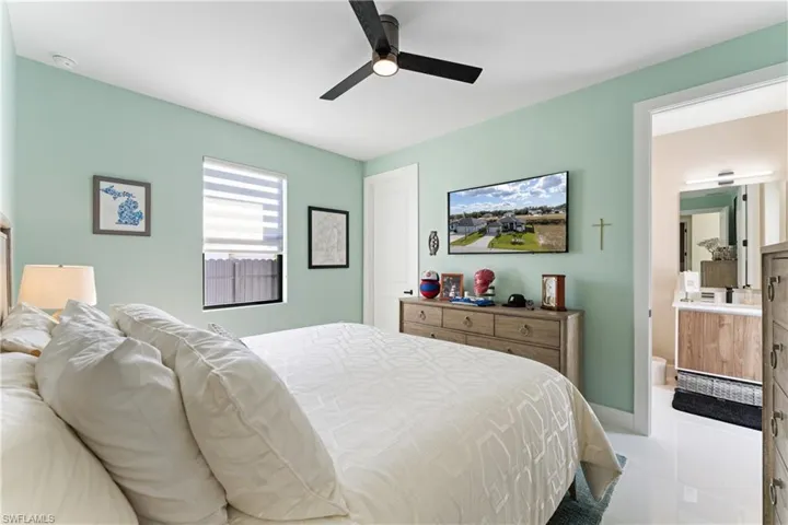 Tiled bedroom featuring a ceiling fan and baseboards