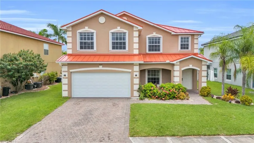 View of front of house featuring a garage, central AC unit, and a front yard
