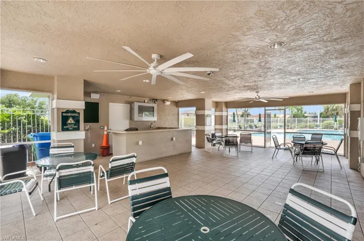 View of patio featuring a community pool and ceiling fan