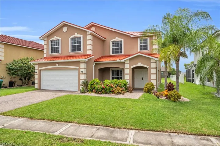 Mediterranean / spanish-style home with a garage and a front lawn