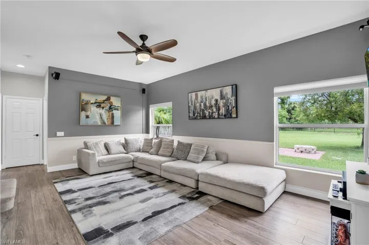 Living room with ceiling fan and hardwood / wood-style flooring