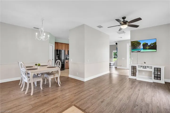 Dining space featuring ceiling fan with notable chandelier and hardwood / wood-style floors