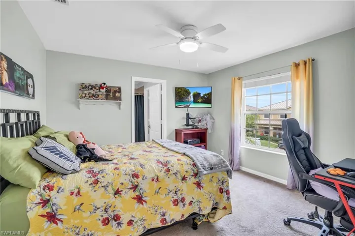 Carpeted bedroom featuring ceiling fan