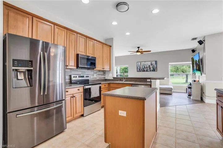 Kitchen featuring appliances with stainless steel finishes, tasteful backsplash, plenty of natural light, and a kitchen island