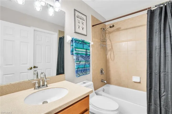 Full bathroom with vanity, shower / tub combo, and toilet