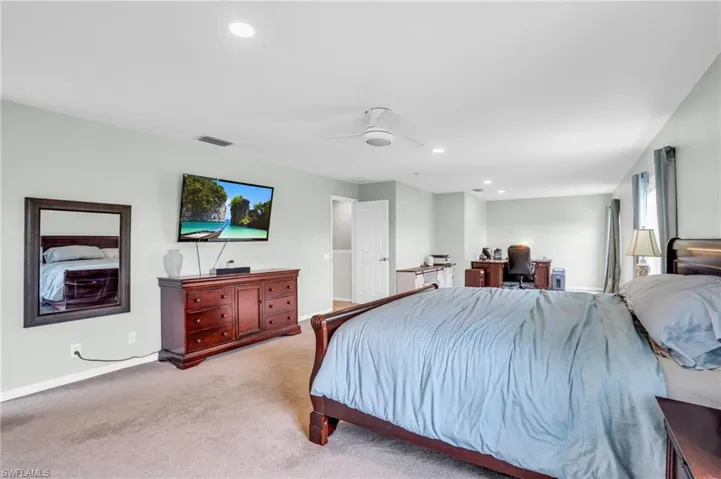 Carpeted bedroom featuring ceiling fan