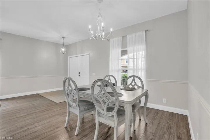 Dining space with dark hardwood / wood-style flooring and a chandelier