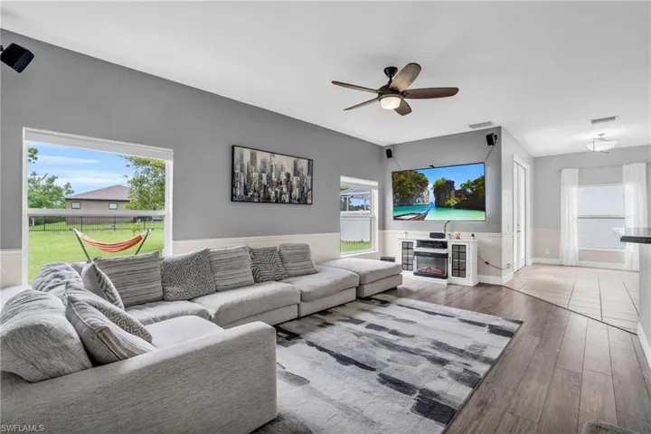 Living room with a fireplace, hardwood / wood-style floors, and ceiling fan