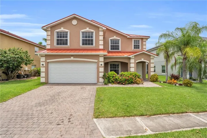 View of front of property featuring a garage and a front yard