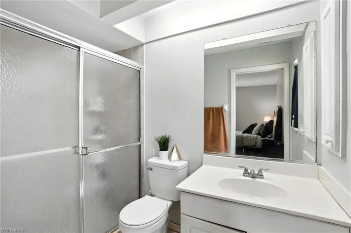 Bathroom with ensuite bathroom, a stall shower, and vanity